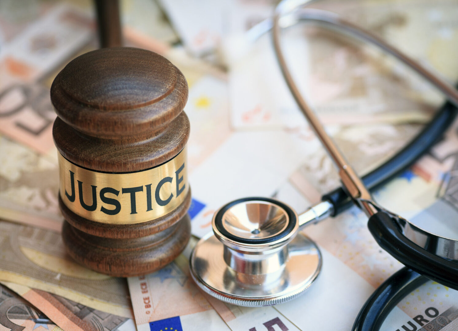 A judge 's gavel and stethoscope on top of papers.